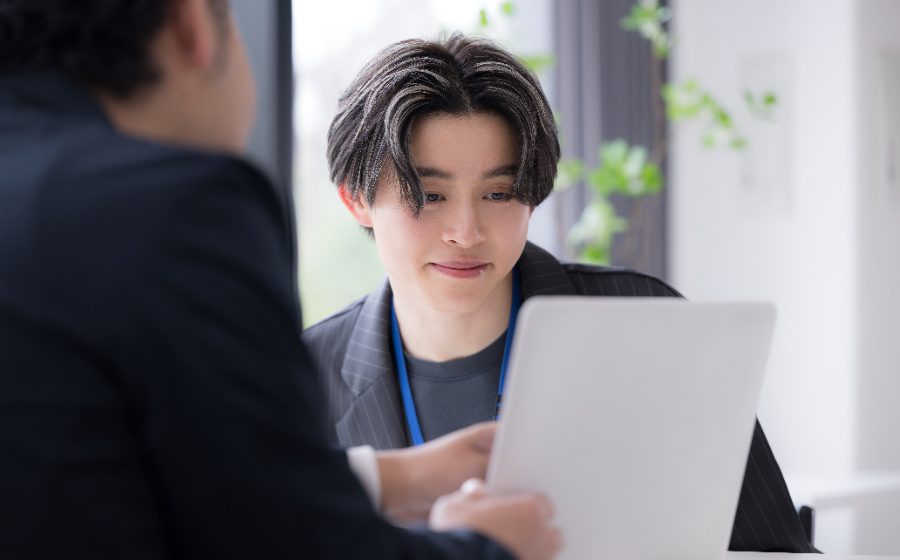 担当者とノートパソコンを見ながら相談する学生